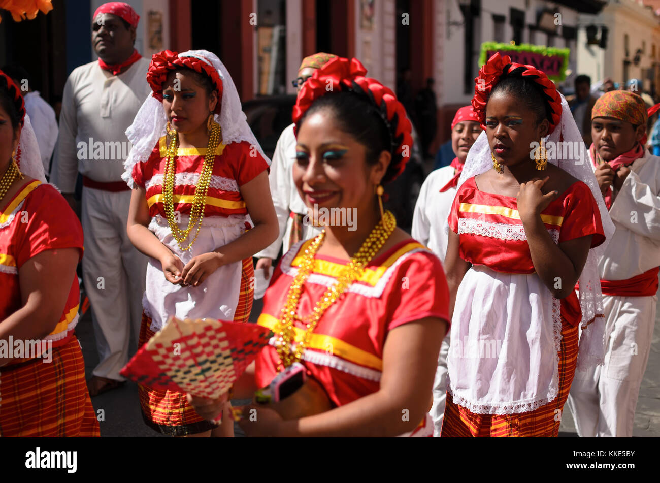 Mexican women in traditional dresses on local parade walking along the streets in downtown Stock Photo