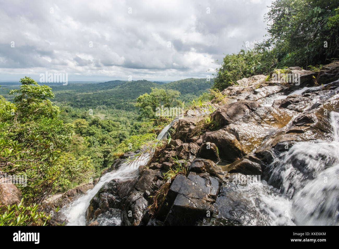 A rocky mountainside in the jungles of Belize with a stream splashing down the side of it.  A beautiful wilderness. Stock Photo