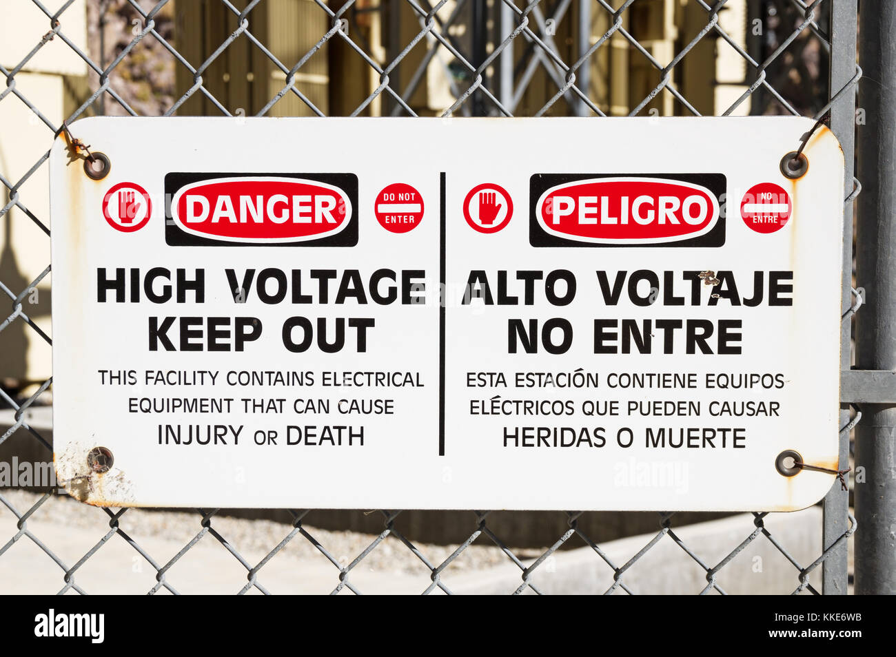 danger high voltage keep out sign on a chain link fence around electrical equipment Stock Photo