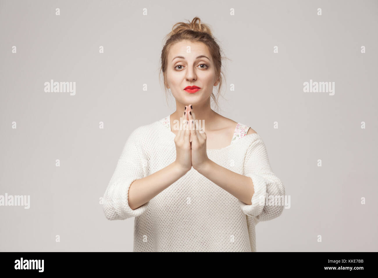 Please sorry! Hopeless woman hope, wish or apologize . Indoor shot Stock Photo
