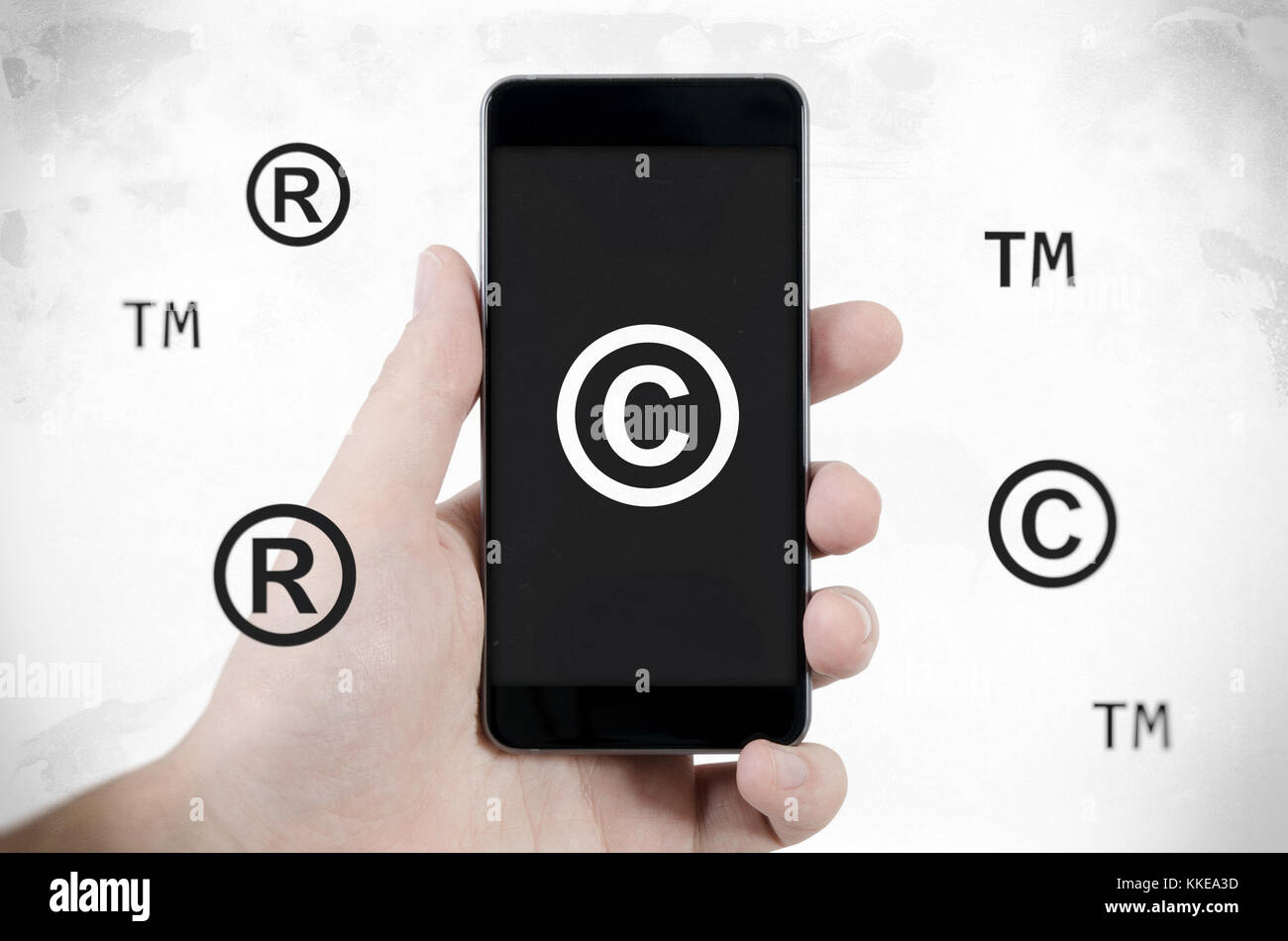 Copyright, trademark symbols flying around smartphone. Security and piracy composition. Dirty noise style Stock Photo