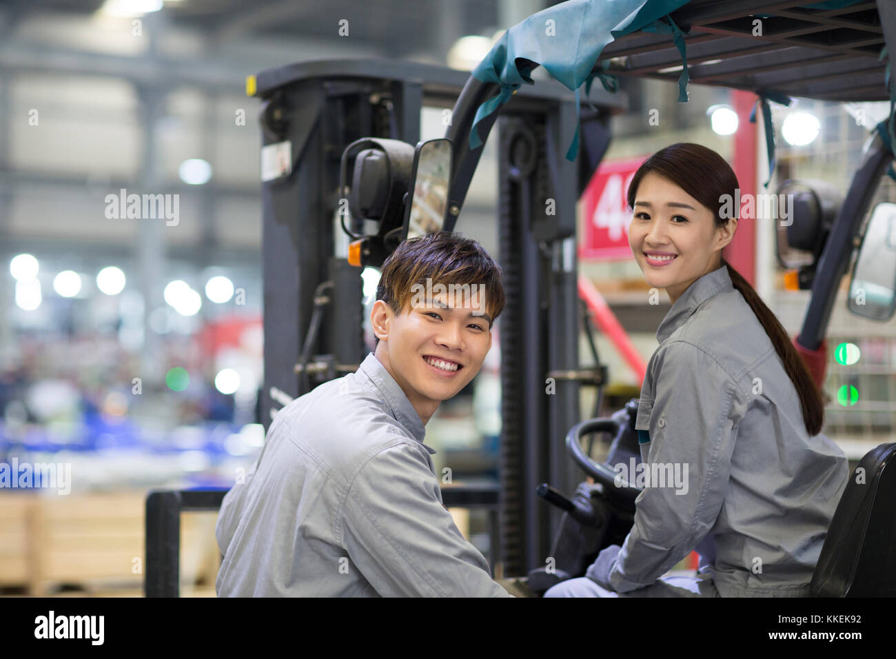 Confident Chinese workers driving forklift in the factory Stock Photo