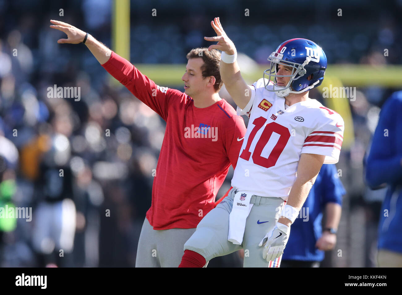 Oakland, USA. December 3, 2017: New York Giants quarterback Eli Manning (10) and New York Giants quarterback Davis Webb (5) do a wave together after a pre-game chat in the game between the New York Giants and Oakland Raiders, Oakland Coliseum, Oakland, CA. Peter Joneleit Stock Photo