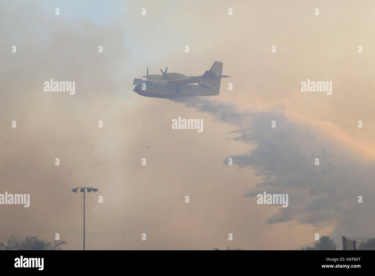 California, USA. 5th Dec, 2017. A plane drops water in Ventura County of California, the United States, Dec. 5, 2017. Brush fires across the region were fed by extremely high winds, low humidities and dry fuel. Hundreds of fire fighters have been working very hard to minimize damage to property and evacuations are taking place in many places in south California, said authorities. Credit: Huang Heng/Xinhua/Alamy Live News Stock Photo