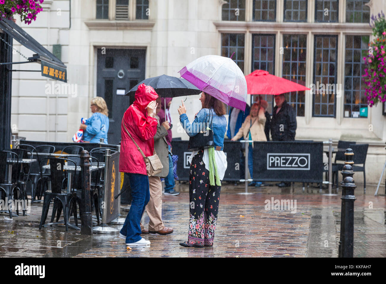 Canterbury, Kent, UK. 29th September 2017. A group of ladies with umbrellas talking in the pouring rain in the high street. Stock Photo