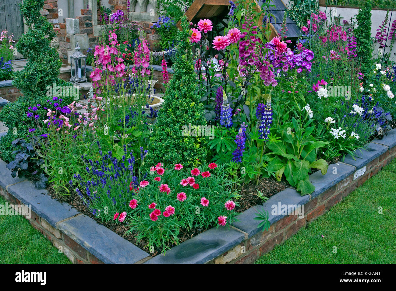 Colourful planting in a raised bed of a small urban garden Stock Photo