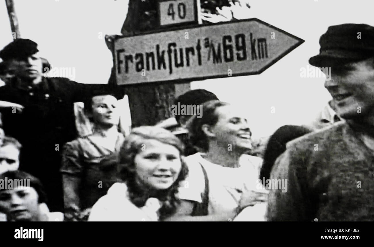 German children watching a Nazi parade circa 1939 with a sign to Frankfurt, Germany behind them Stock Photo