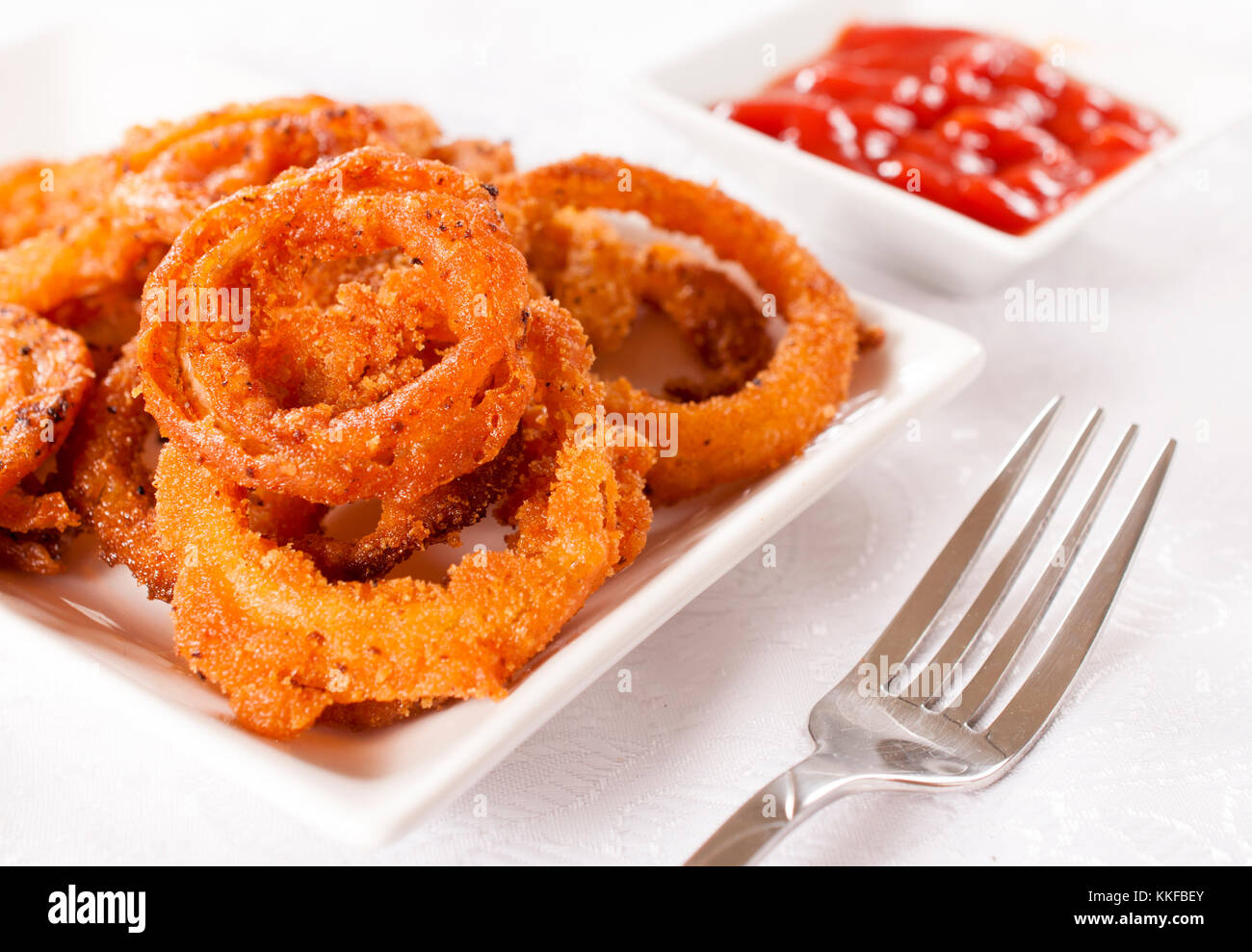 Deep fried homemade onion rings on the plate.Selective focus on the onion rings Stock Photo