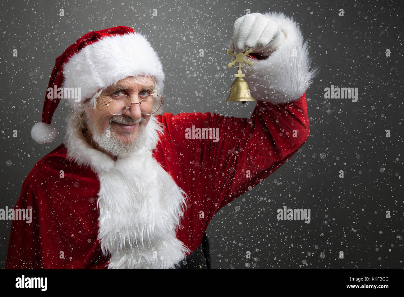 Jingle bells. Santa Claus holding metal bell in his hand and against