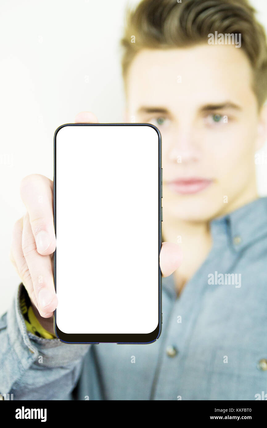 Handsome millennial showing generic blank full screen smartphone Stock Photo