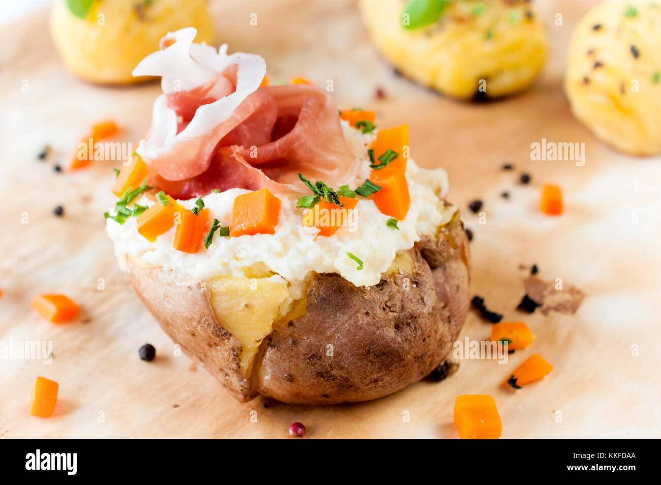 Fresh baked potato and prusciutto with white cheese cream Stock Photo