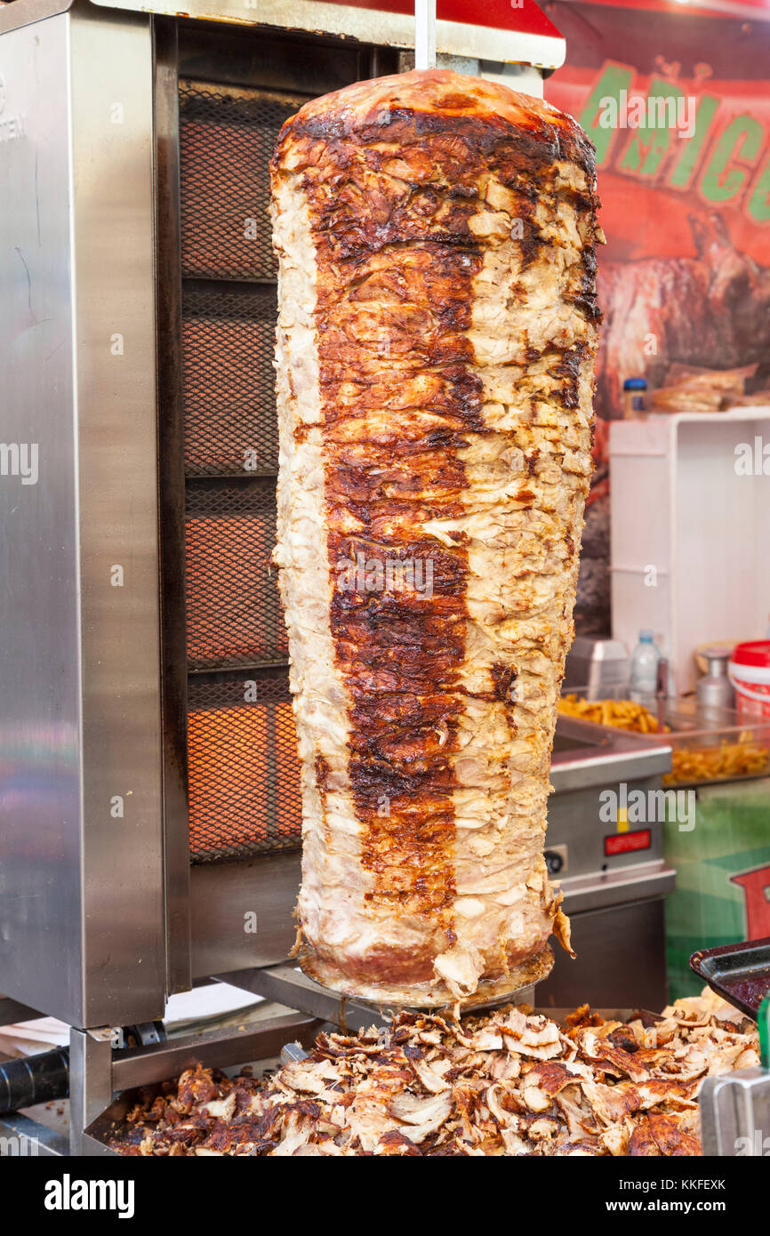 Traditional doner kebab with stacked pork grilling on a rotisserie in