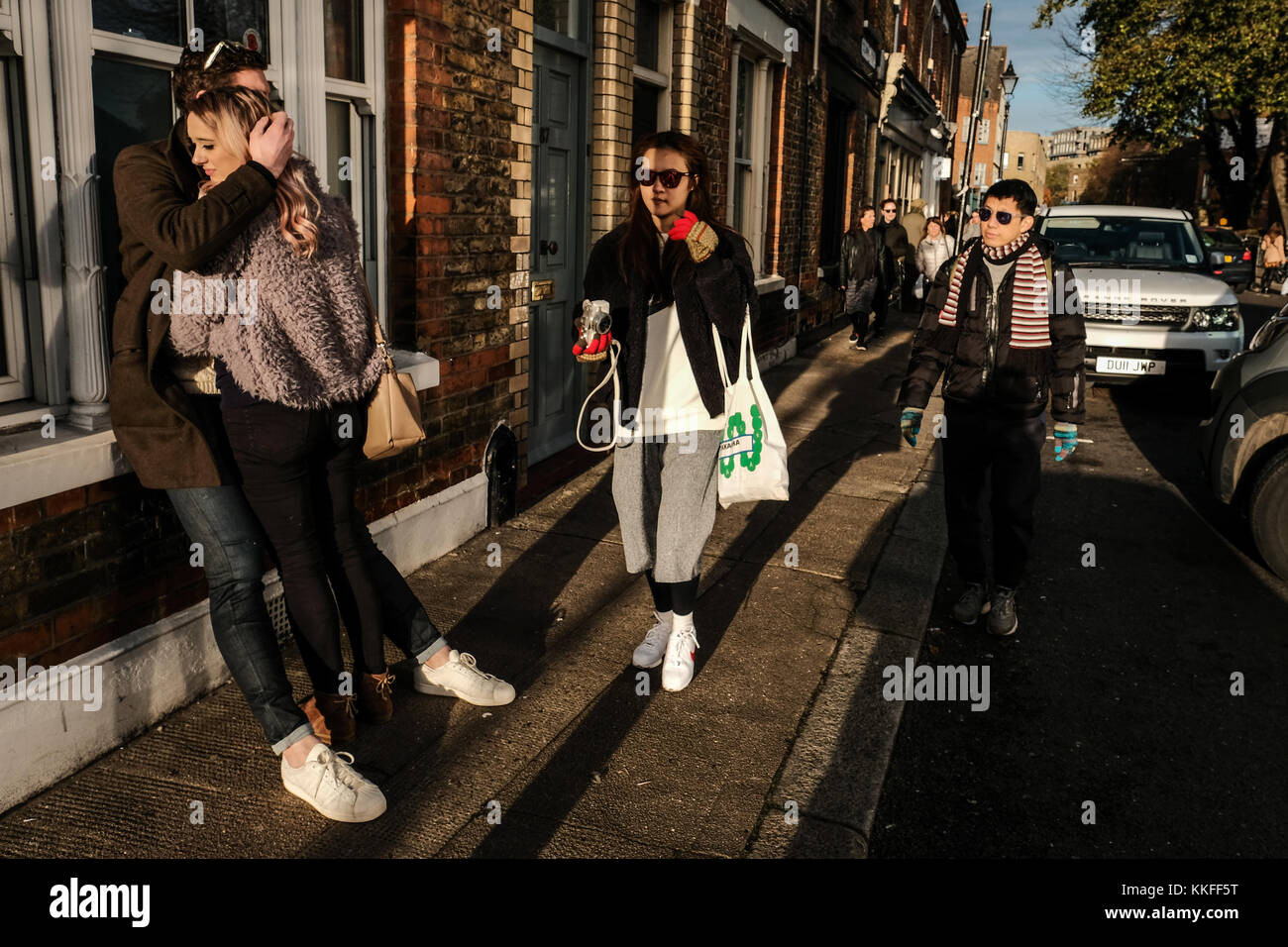 A tender moment as a couple cuddle each other on Columbia Road, London, UK Stock Photo