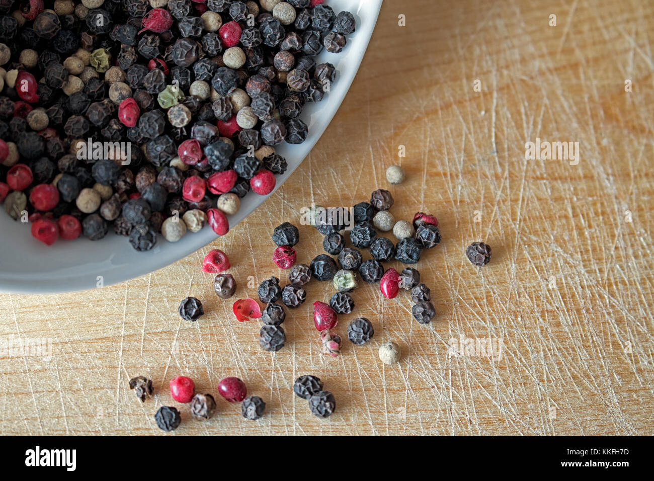 Mixed peppercorns on wooden surface Stock Photo