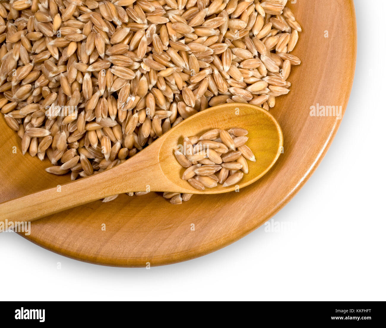 wooden plate with grains of dinkel, close-up Stock Photo