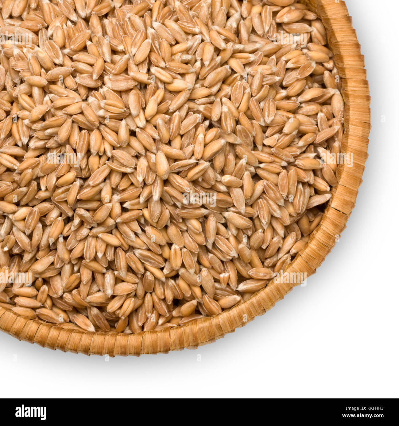 wheat dinkel close-up on a plate of straw isolated on white background Stock Photo