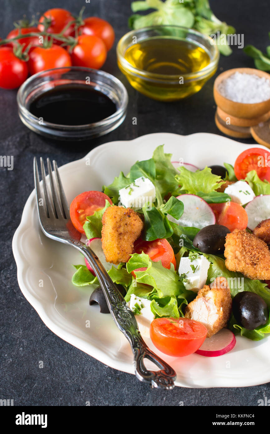 Fresh chicken salad and feta cheese with vegetables in the plate