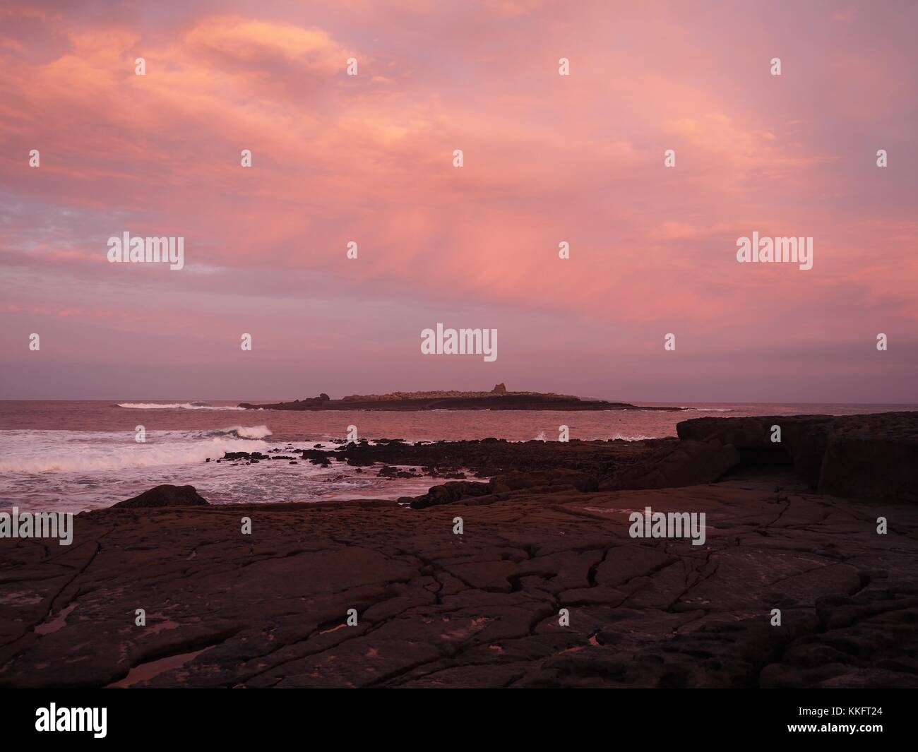 The sun rises over the Wild Atlantic Way at Doolin Pier, County Clare, Ireland turning the rock pools a sunburst red. Stock Photo