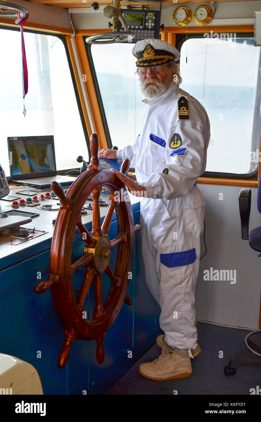 The master of the ship, old experienced captain in navigation cabine Stock Photo
