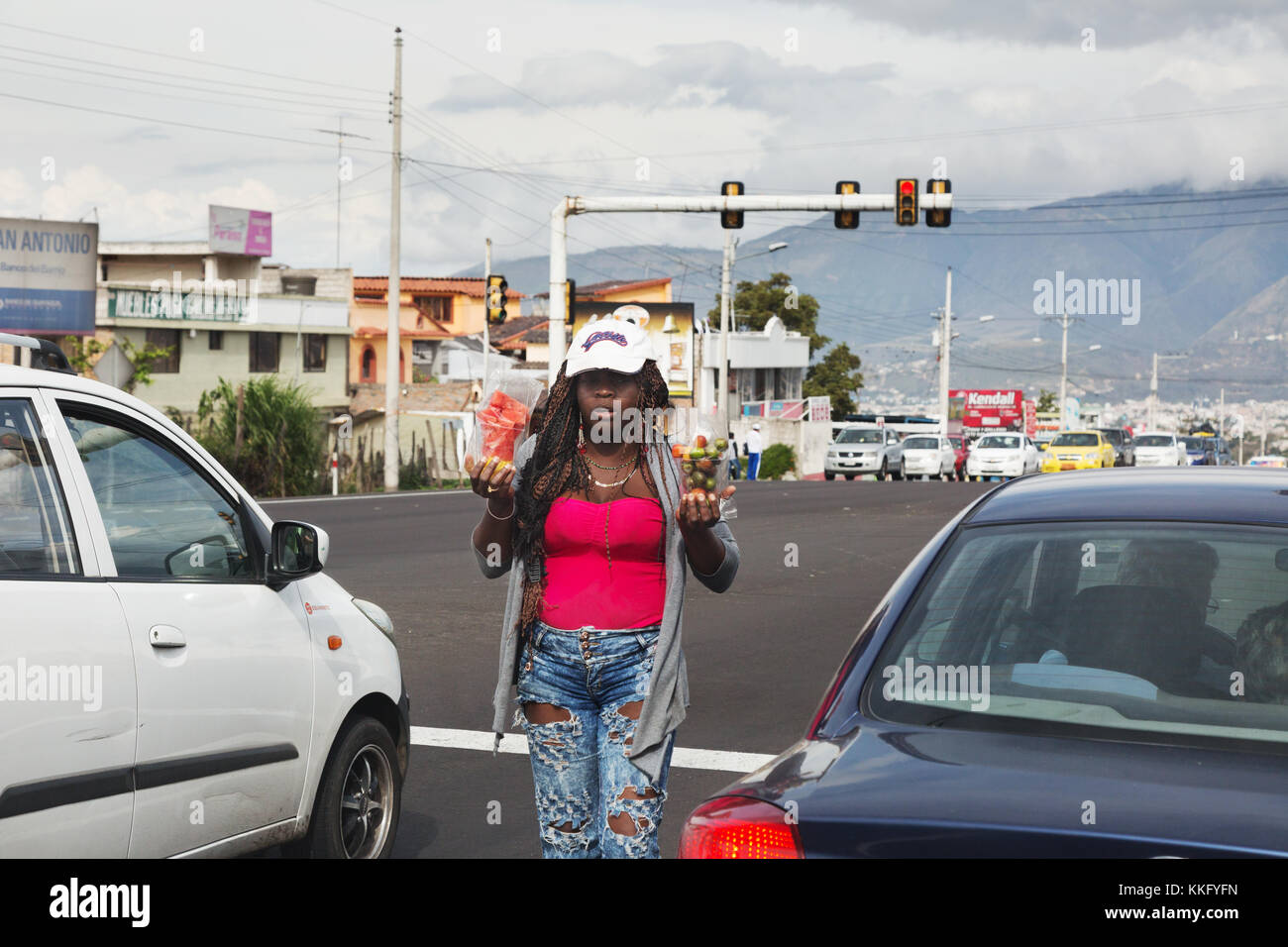 Afro-Ecuadorian woman selling goods to car drivers stopped at traffic lights, Ecuador, South America Stock Photo