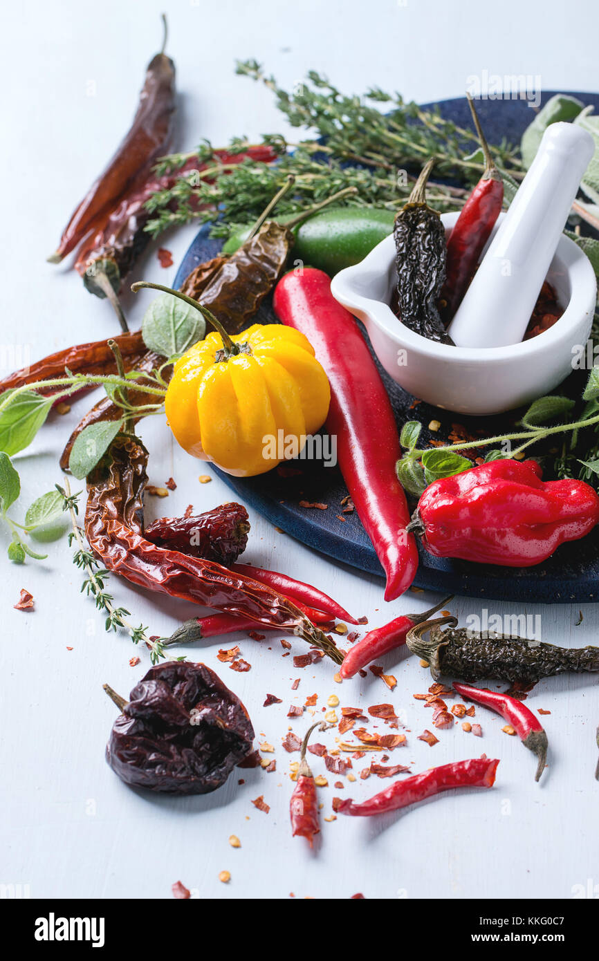 Assortment of fresh, dryed and flakes hot chili peppers and fresh herbs ...