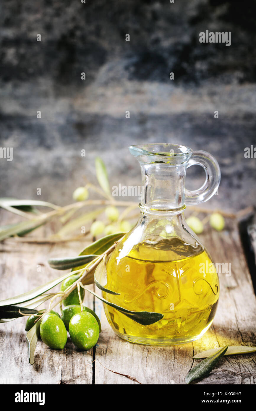 Battle of olive oil with olive branch over wooden table Stock Photo - Alamy