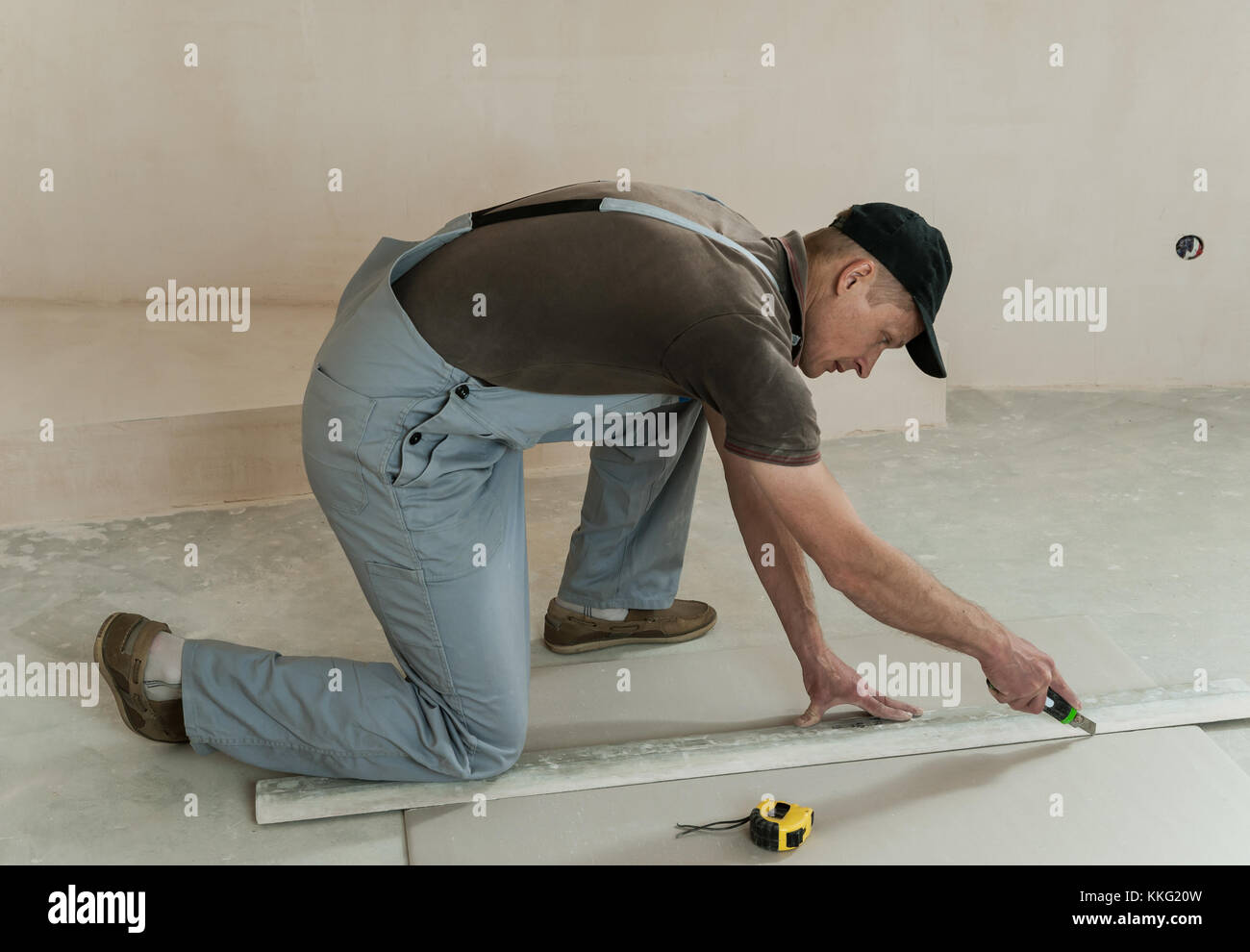 Dry Wall Ruler Worker cuts a piece of drywall with a knife and a ruler Stock Photo - Alamy