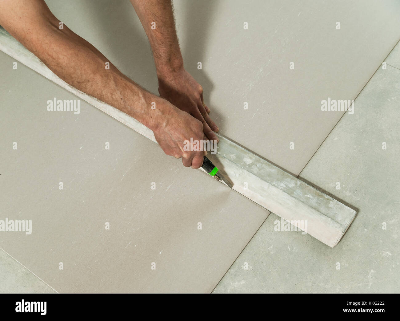 Dry Wall Ruler Man cuts off a piece of drywall with a knife and a ruler Stock Photo ...