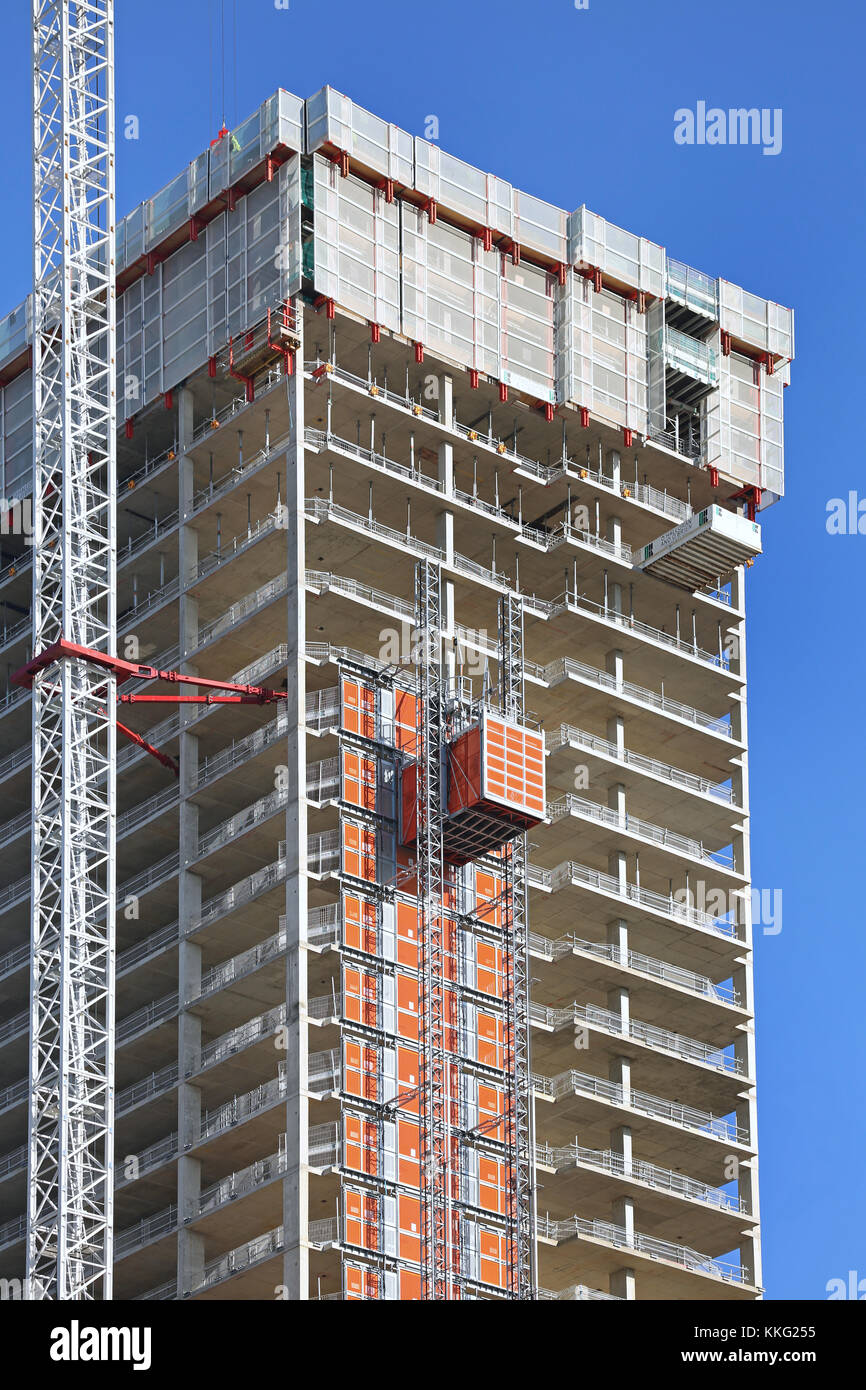 A new tower block under construction on London's Canary Wharf. Shows personnel hoist and climbing screens. Stock Photo