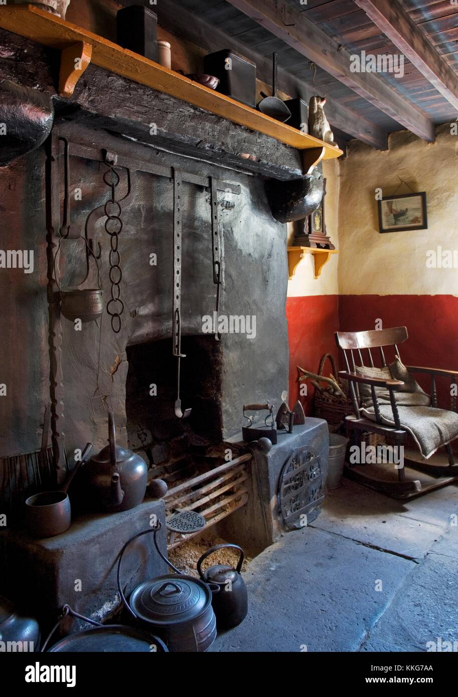 Ulster Folk and Transport Museum, Cultra, Belfast. 19th C. Coshkib Hill Farm. Fireside with cranes, hobs, rocking chair. Stock Photo