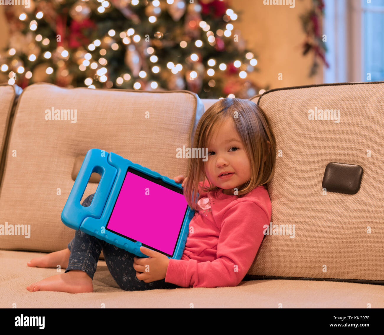Preschool girl using a tablet computer at home at Christmas Stock Photo