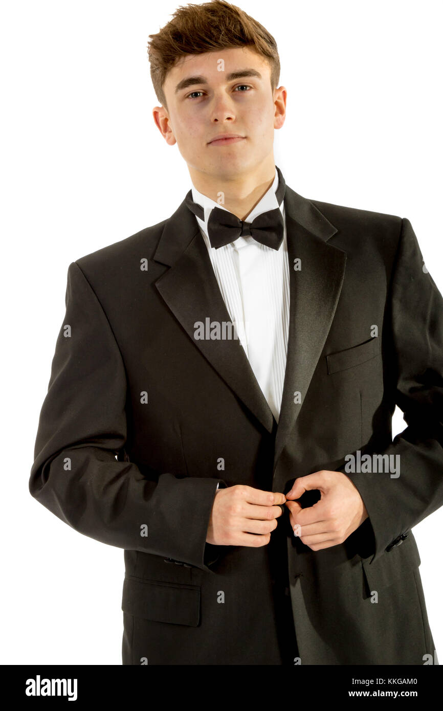 18 year old wearing a tuxedo doing up his jacket isolated on a white background Stock Photo