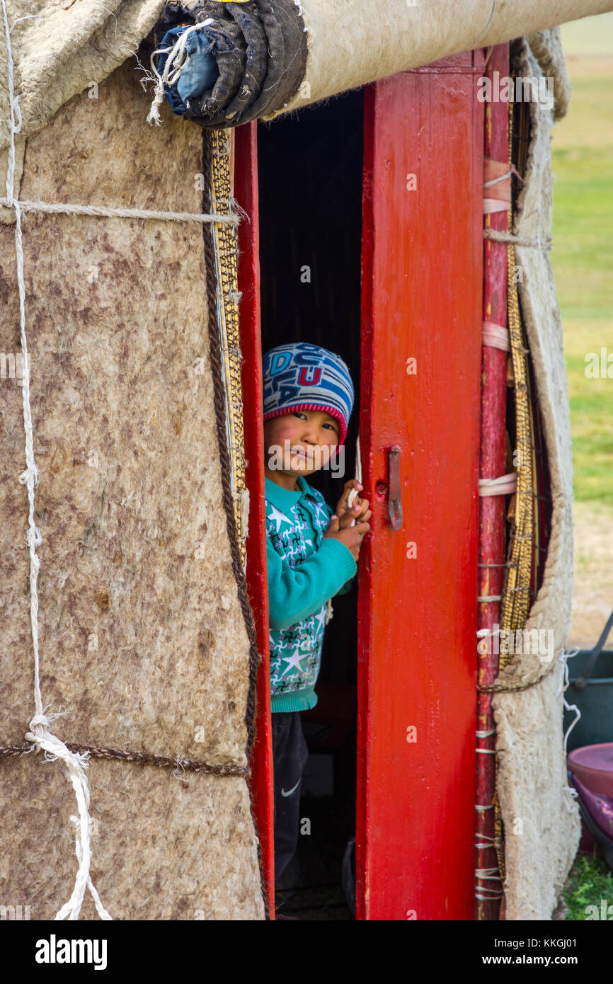 SONG KUL, KYRGYZSTAN - AUGUST 10: Portrait of a young boy looking out the yurt, typical central asian nomad house. August, 2016 Stock Photo
