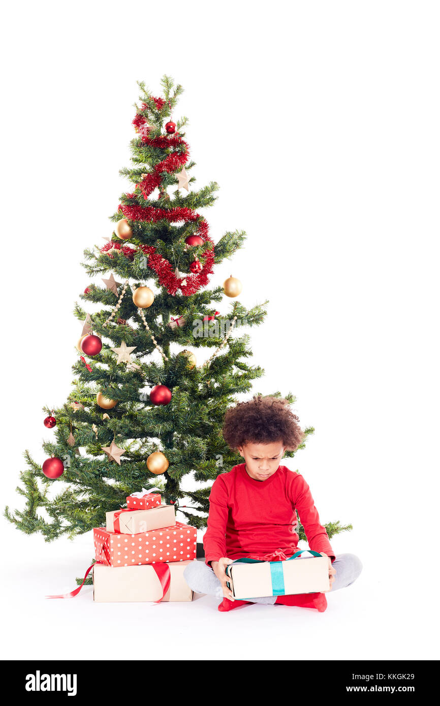 Mixed race boy near Christmas tree Stock Photo