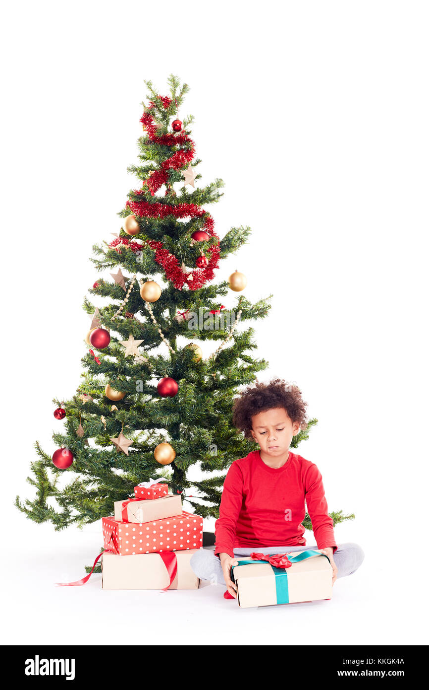 Mixed race boy near Christmas tree Stock Photo