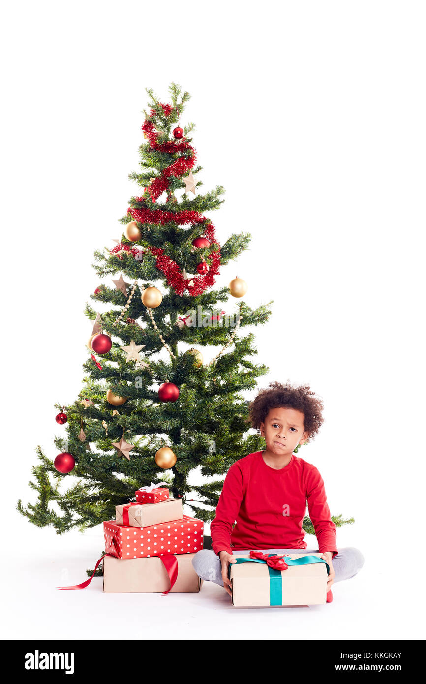 Mixed race boy near Christmas tree Stock Photo