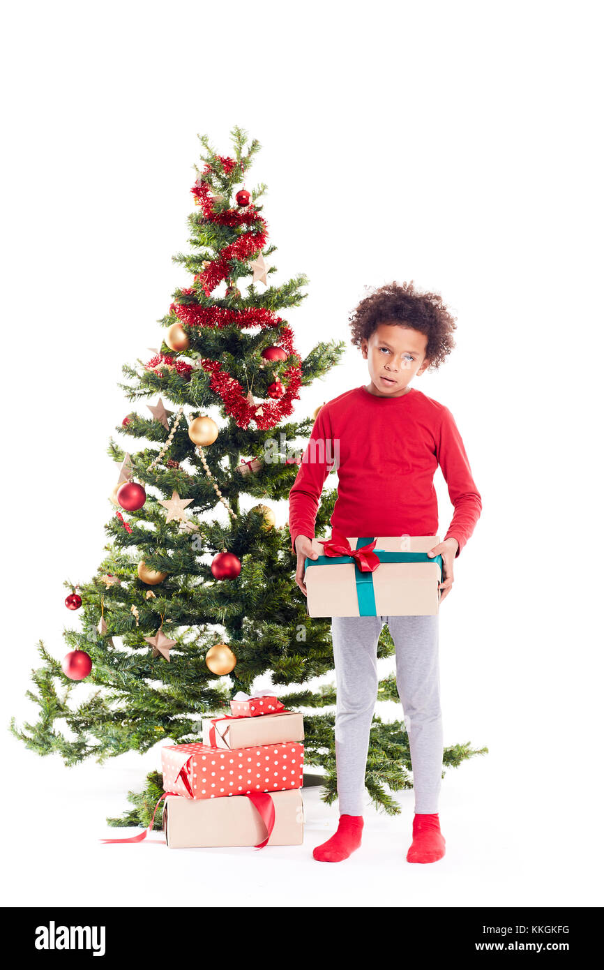 Mixed race boy near Christmas tree Stock Photo