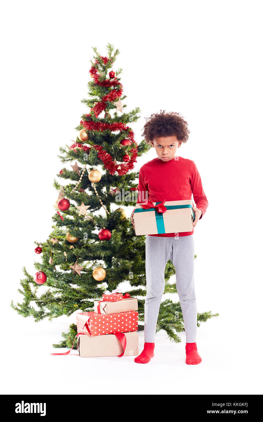 Mixed race boy near Christmas tree Stock Photo