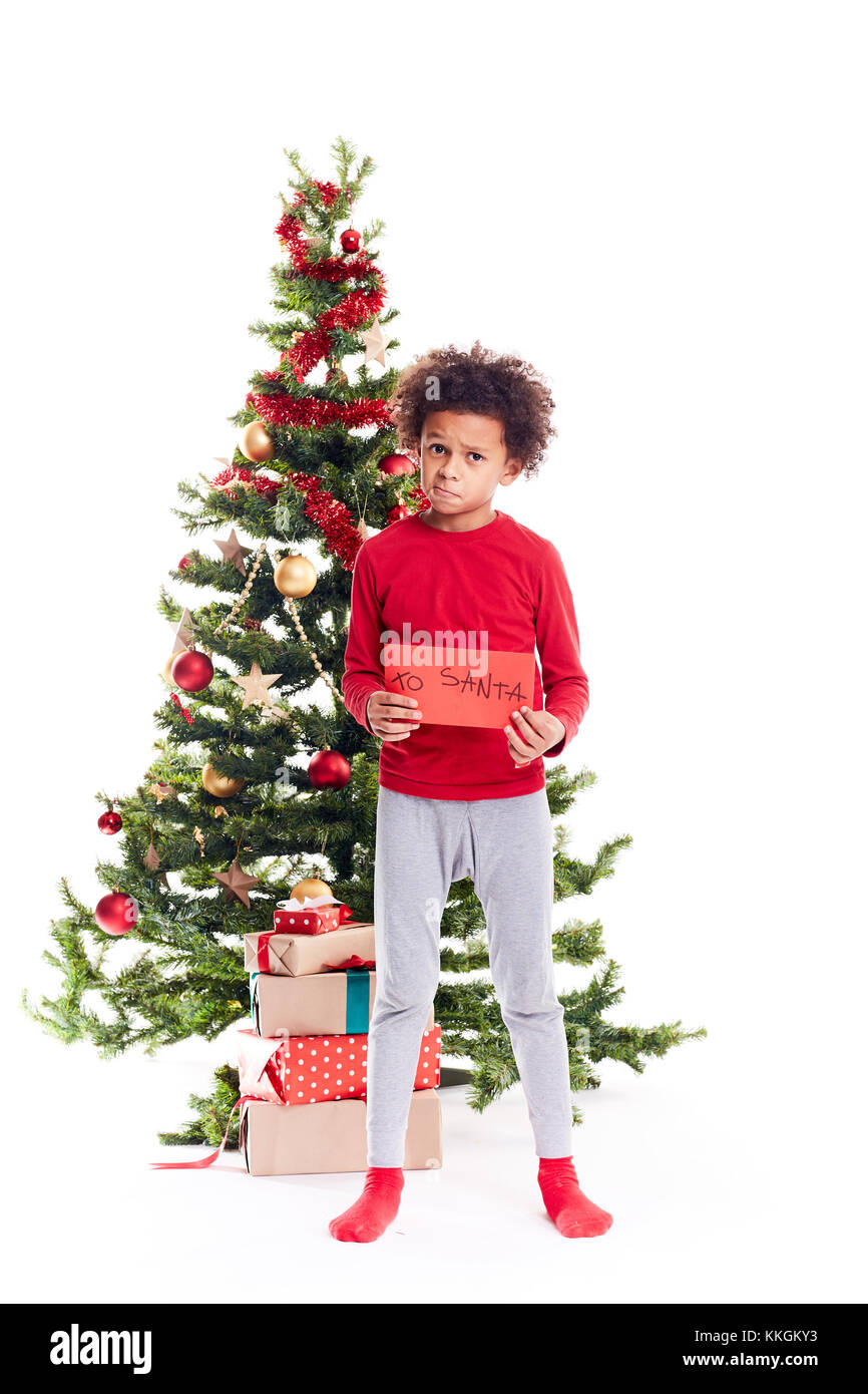 Mixed race boy near Christmas tree Stock Photo