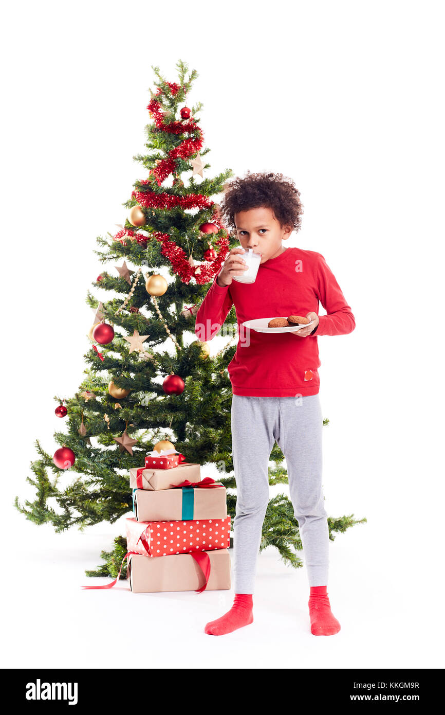 Mixed race boy near Christmas tree Stock Photo