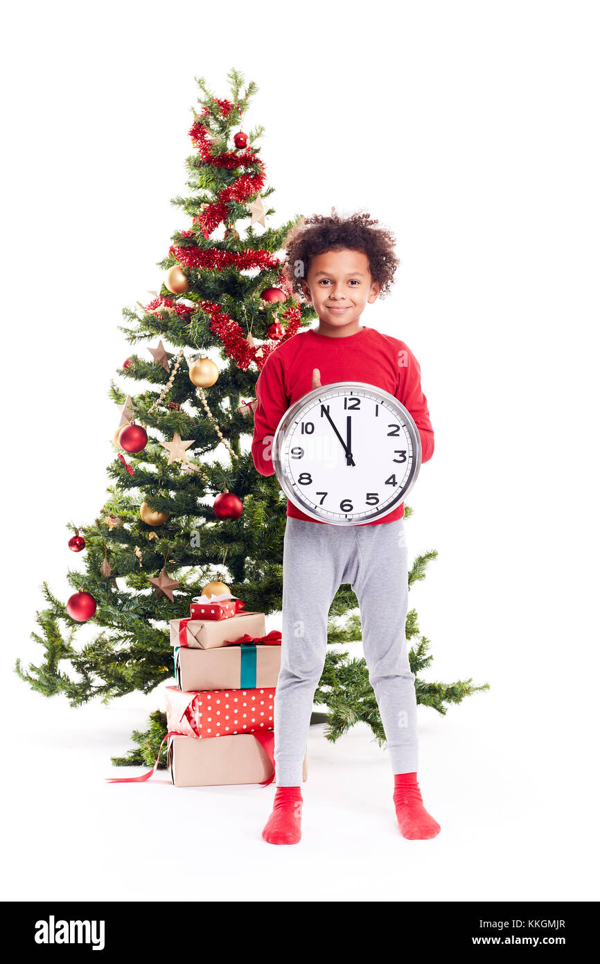 Mixed race boy near Christmas tree Stock Photo