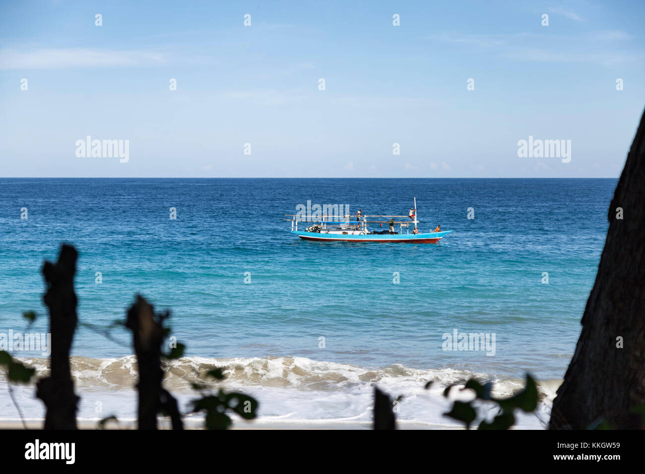 A solo fisihng vessel in the tropical waters in Paga a small village on the island of Flores, Indonesia. Stock Photo