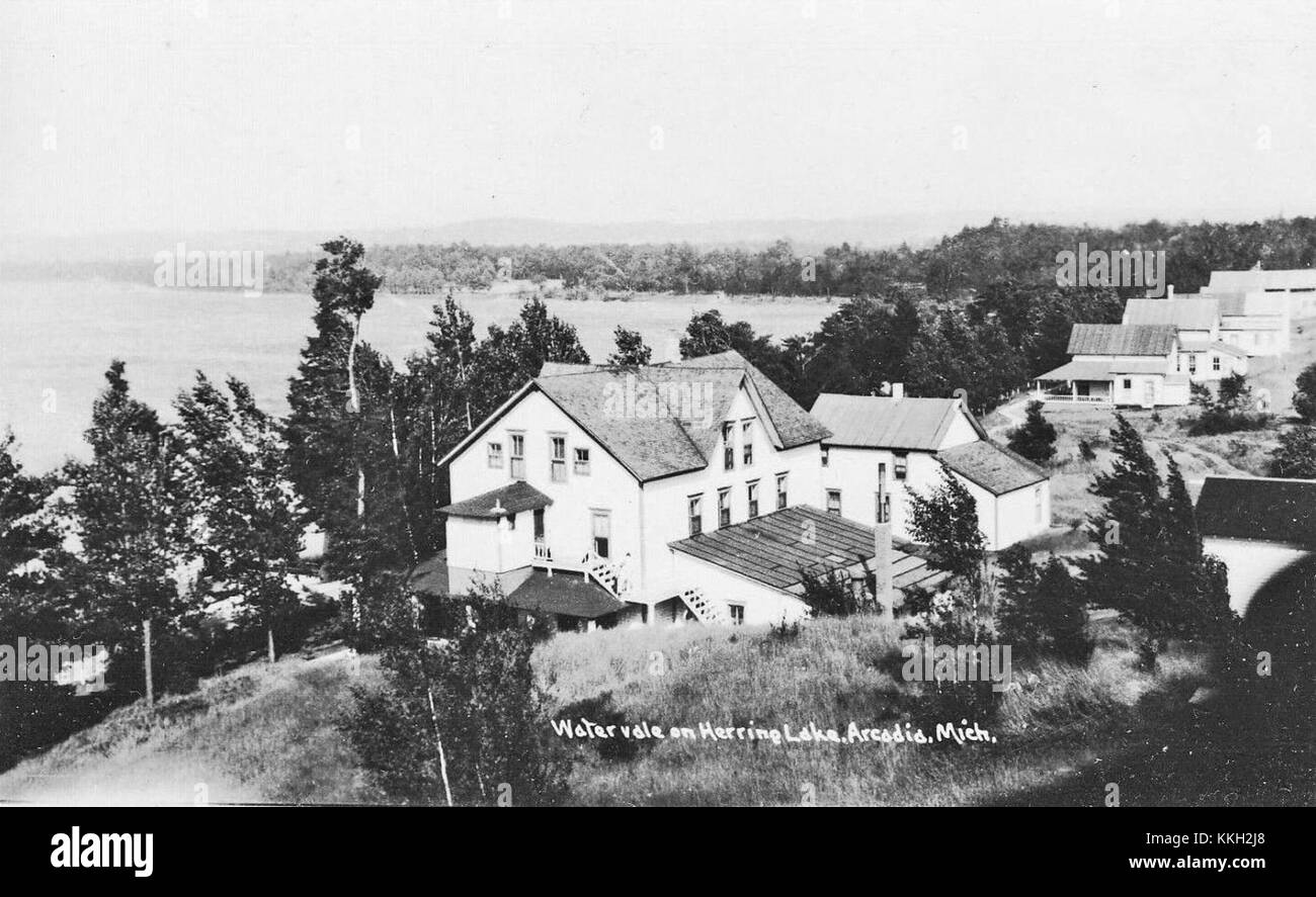 This black-and-white photograph depicts Watervale, Michigan in the 1940s. It captures a glimpse of the small town during the mid-20th century, reflecting the period's architecture and rural setting. Stock Photo
