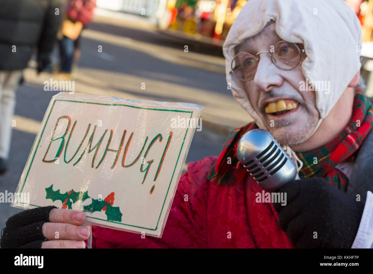 Portsmouth, Hampshire, UK. 1st Dec 2017. Crowds visit the Victorian Festival of Christmas at Portsmouth Historic Dockyard for the entertainment, characters dressed in olden days and the Christmas market. Ebenezer Scrooge holds bumhug sign. Credit: Carolyn Jenkins/Alamy Live News Stock Photo
