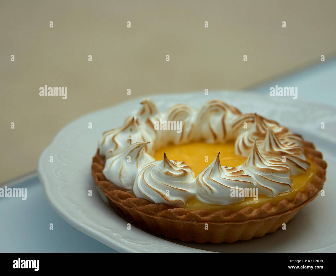 A Lemon Meringue Tart is a dessert consisting of a tangy lemon curd filling, topped with fluffy, golden-brown meringue. It is typically made with a buttery pie crust and is a popular sweet treat in many cultures, combining the sourness of lemon with the sweetness of the meringue. Stock Photo