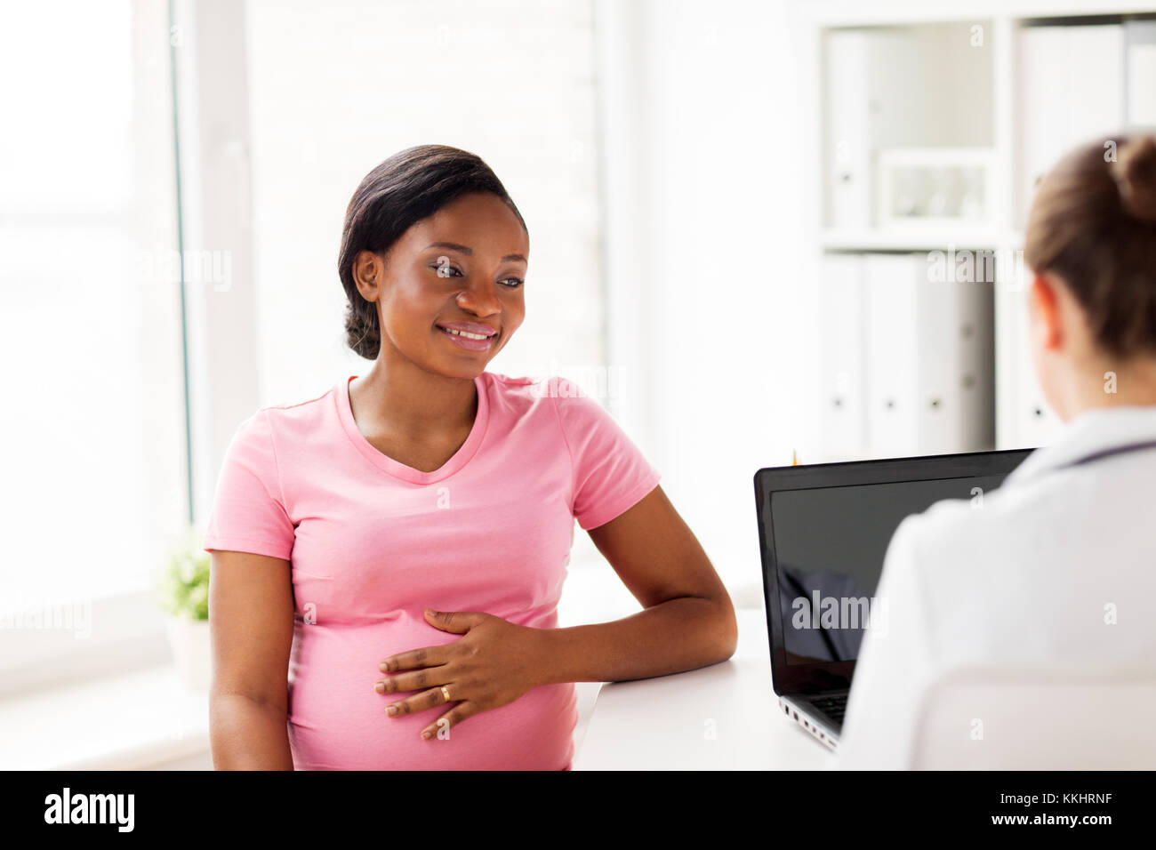 doctor with laptop and pregnant woman at clinic Stock Photo Alamy