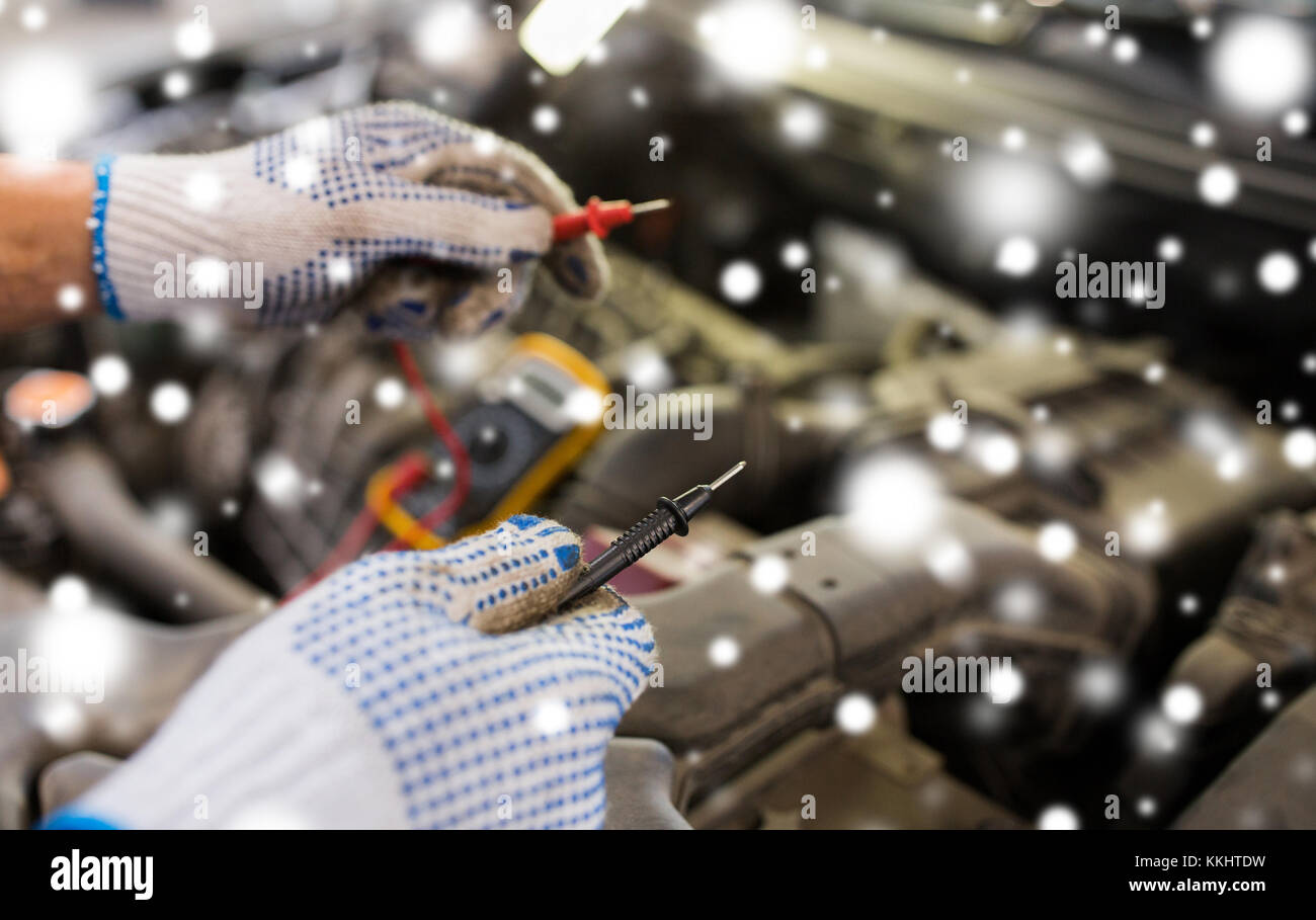 auto mechanic hands with multimeter at car Stock Photo