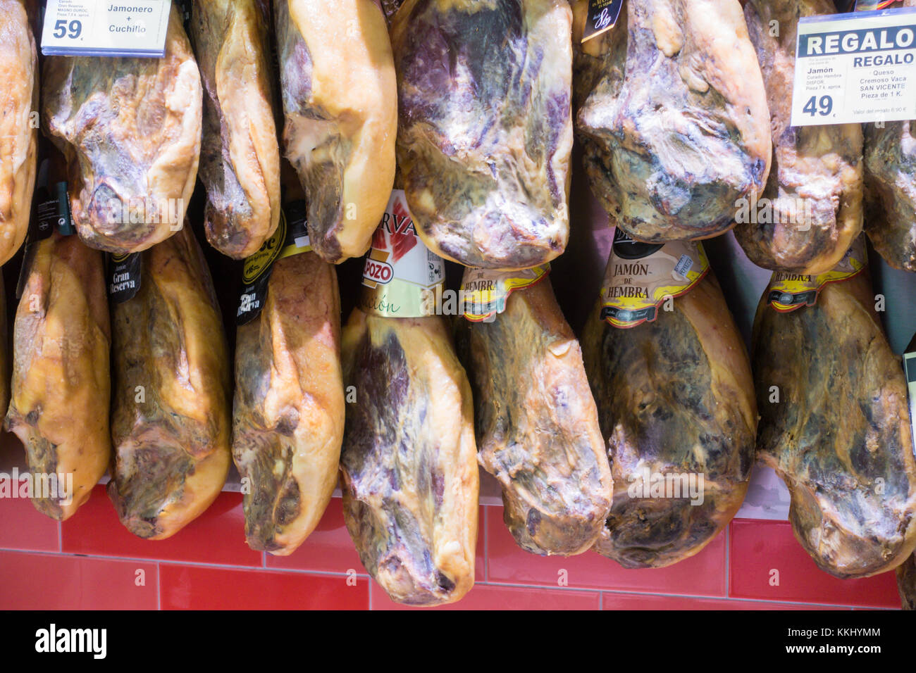 Whole legs of cured Iberian ham hanging in a Spanish supermarket with