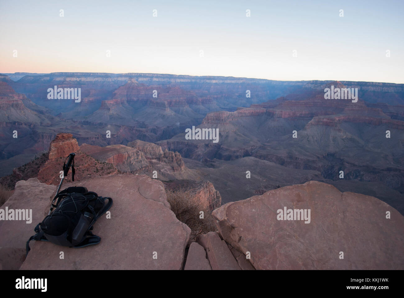 View on Grand Canyon at sunrise with backpack and hiking sticks in the foreground Stock Photo