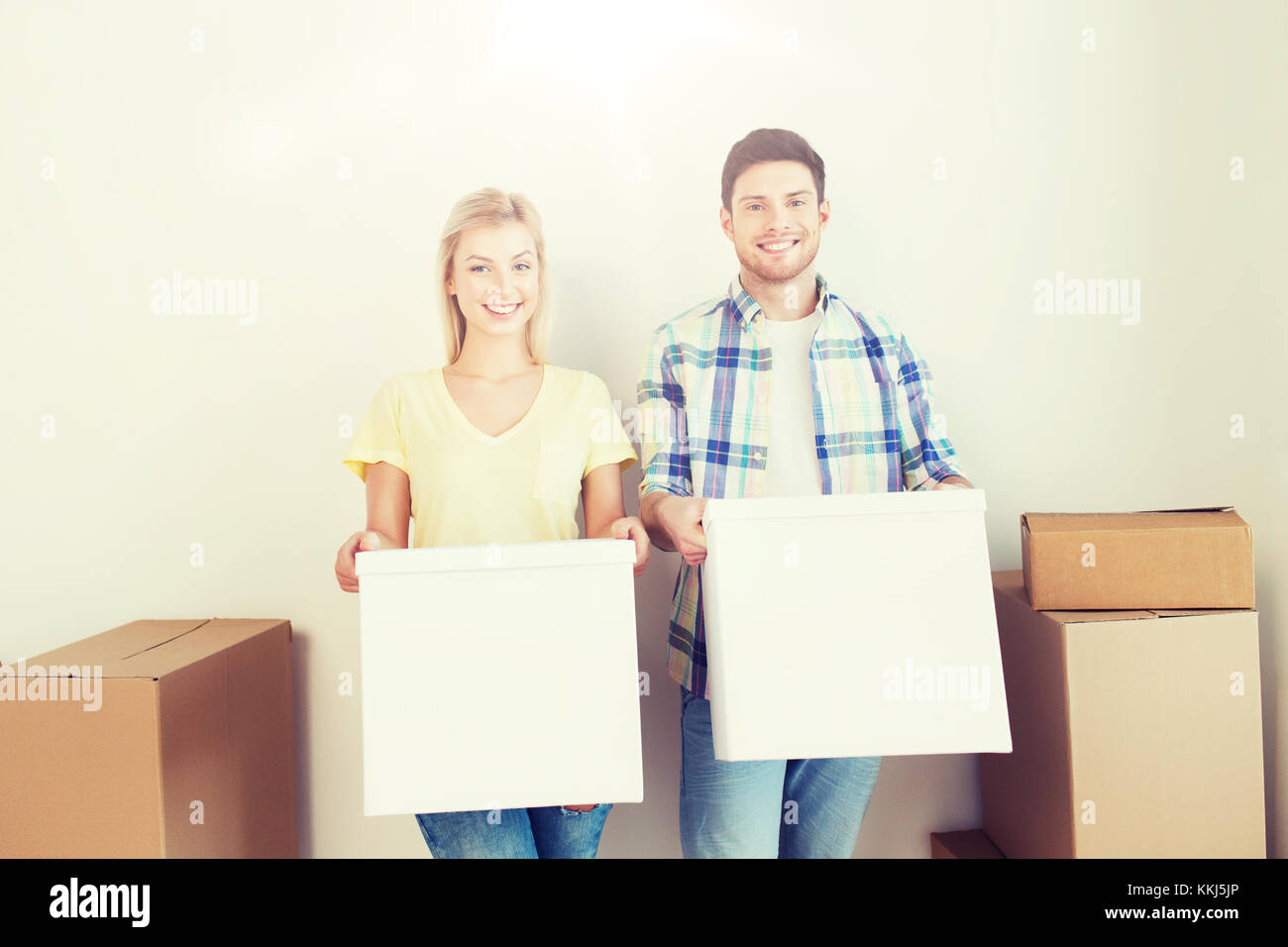 smiling couple with big boxes moving to new home Stock Photo - Alamy
